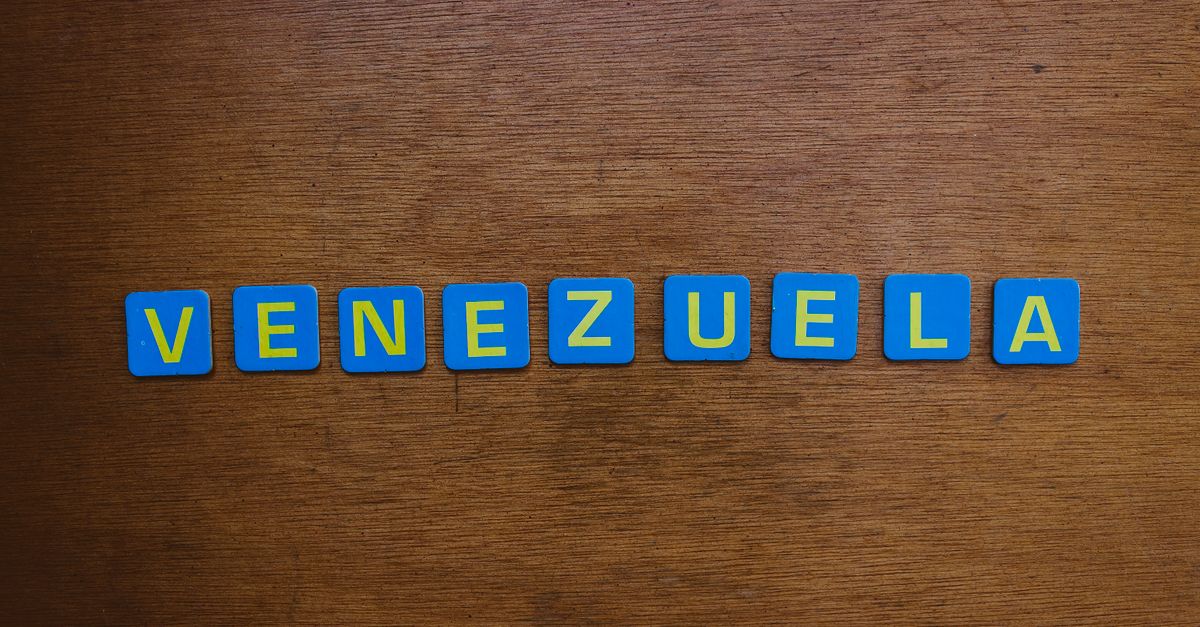 Blue and yellow letter tiles spelling Venezuela on a wooden surface.